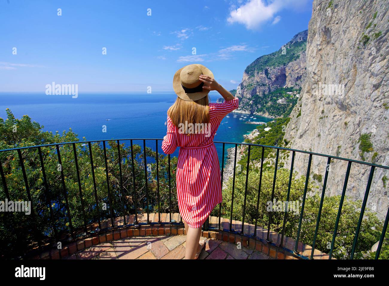 Holidays in Capri, Italy. Young fashion woman enjoying landscape from balcony in Capri Island, Italy. Stock Photo