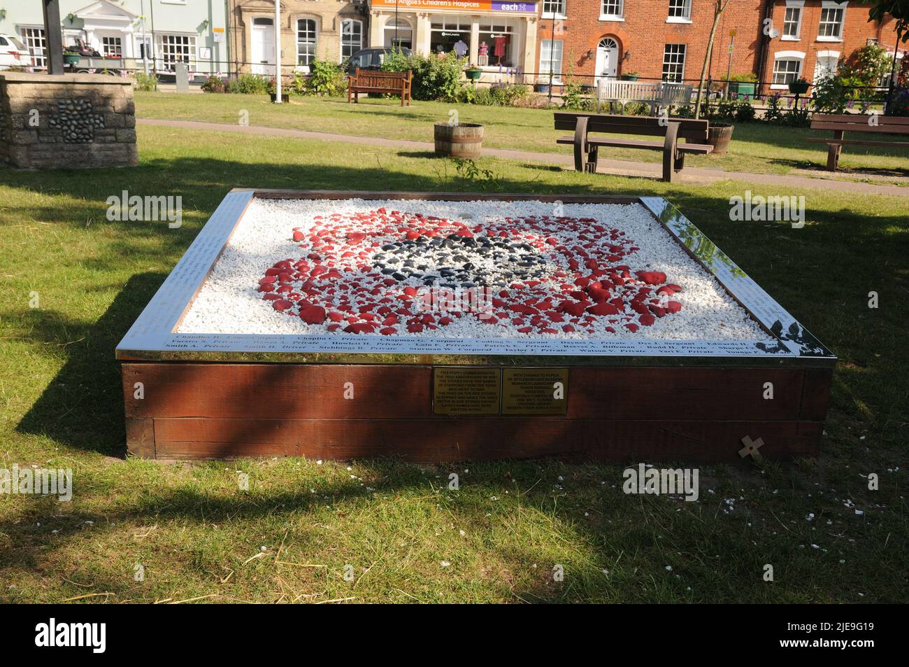 Poppy stone, Attleborough, Norfolk, commemorating the 100th anniversary of WWI. The stones have the names of all who went to war. Those on the red sto Stock Photo