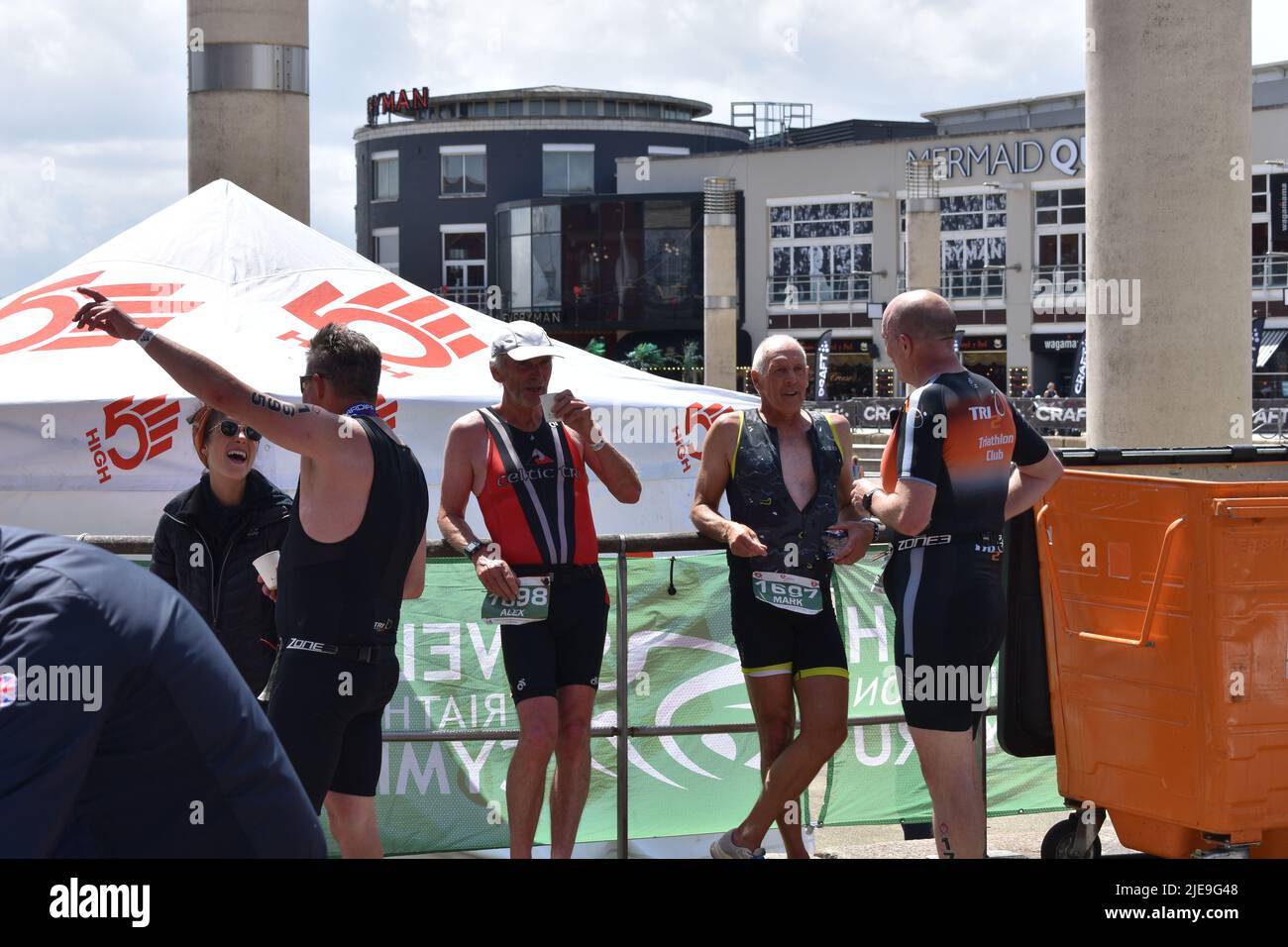 Cardiff Triathlon, Cardiff, Wales, 26th June 2022. Competitors relax after finishing the Cardiff Triathlon, Cardiff Bay. Credit Tiffany Lacey / Alamy Live News Stock Photo
