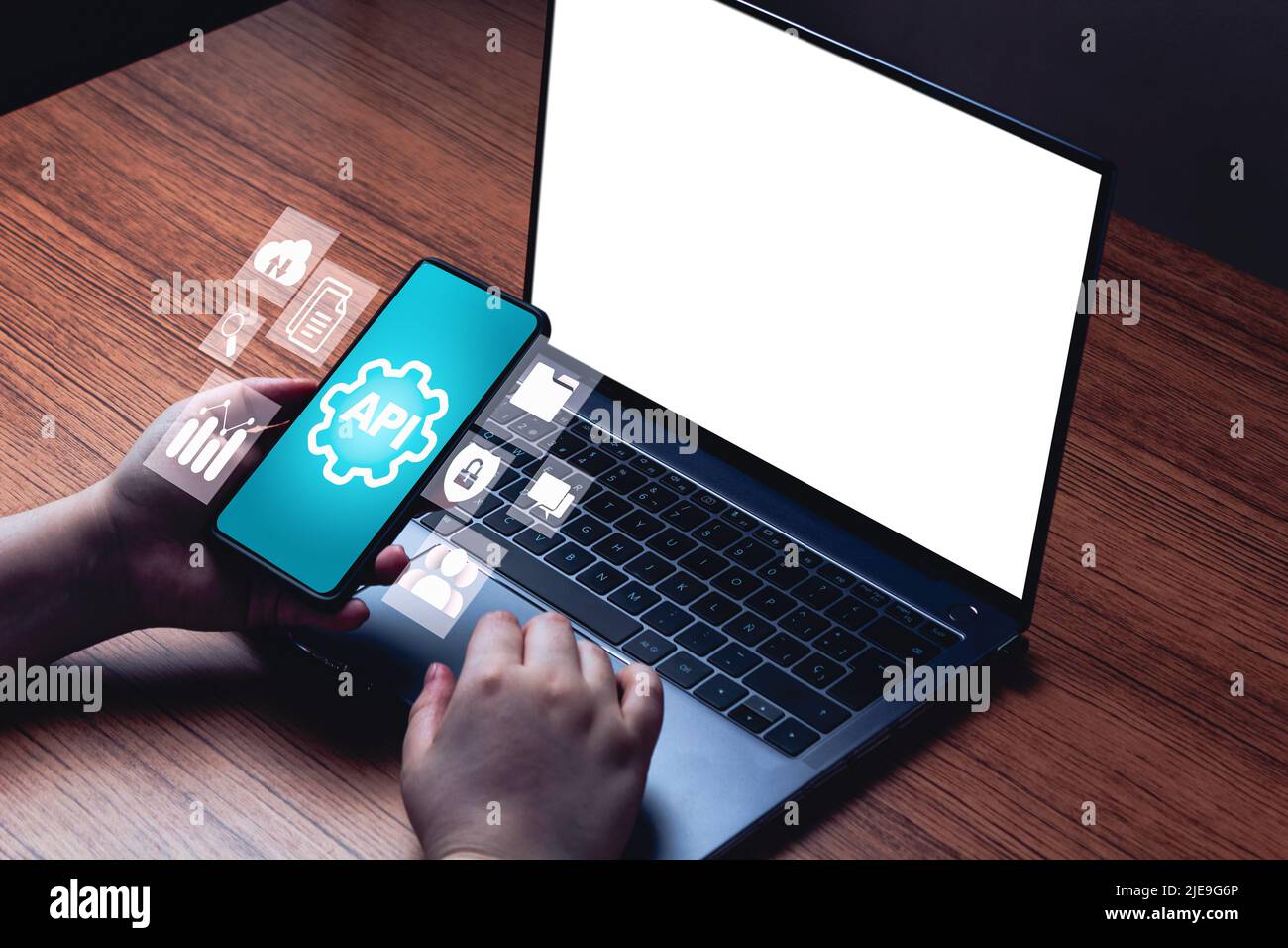 API concept with smartphone interface and blank laptop screen for mockup. Application Programming Interface. Software Development. Stock Photo