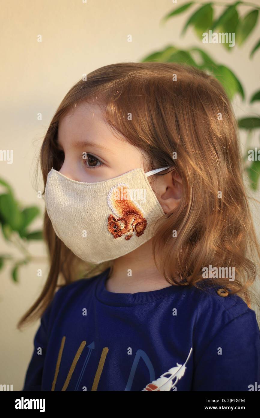 A longhaired toddler wearing a face mask during the Covid19 pandemic Stock Photo Alamy