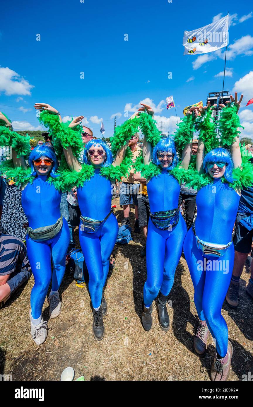 Glastonbury, UK. 26th June, 2022. Fans relax in the sun, some in fancie dress, as Herbie Hancok plays the Pyramid stage - The 50th 2022 Glastonbury Festival, Worthy Farm. Glastonbury, Credit: Guy Bell/Alamy Live News Stock Photo