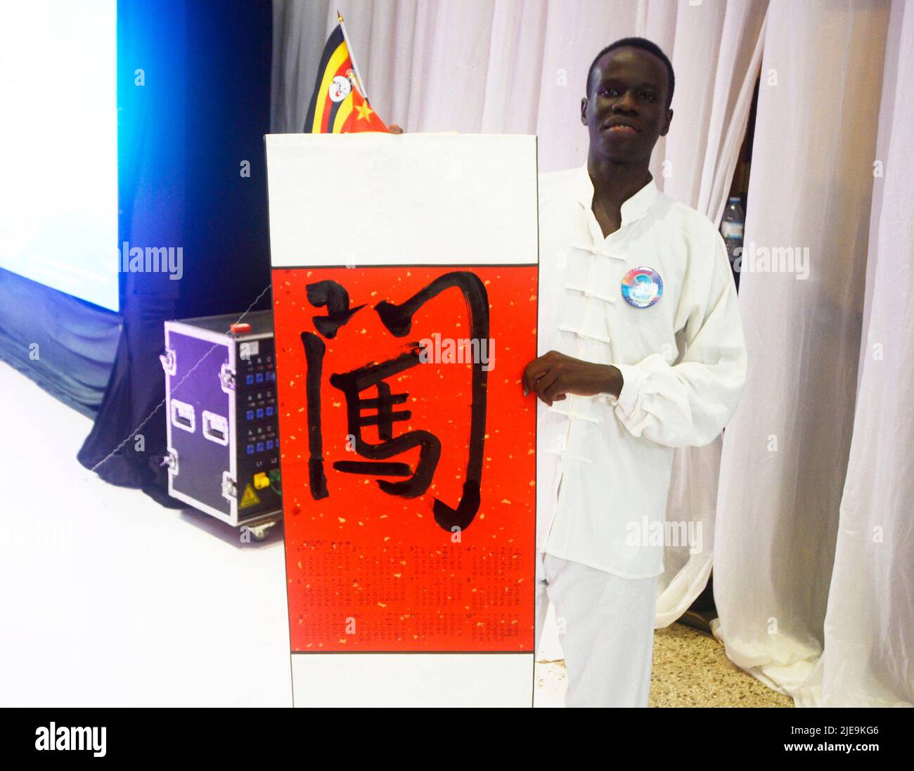 (220626) -- KAMPALA, June 26, 2022 (Xinhua) -- A contestant shows his calligraphy work during the 'Chinese Bridge' Chinese proficiency competition for university and secondary students at the Confucius Institute of Makerere University in Kampala, Uganda, June 25, 2022. This year's competition was organized with the theme 'One world, One Family' for the university category and 'Fly High with Chinese' for the secondary category. During the final round of the competition, a total of 13 finalists from the two categories showcased their Chinese language skills and understanding of the Chinese cu Stock Photo