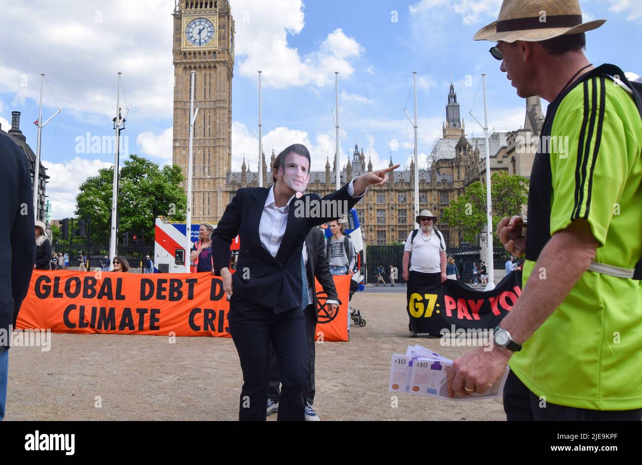 London, UK. 26th June 2022. A protester dressed as French President Emmanuel Macron. Extinction Rebellion activists dressed as G7 leaders played a football match in Parliament Square against ‘Indebted countries', whose players were weighed down by debt chained to their legs, with the match rigged in the G7’s favour by a ‘banker referee’. The action was part of the day’s protest demanding that the G7 cancels the debt of the countries in the Global South, which is forcing the nations to extract fossil fuels to pay off the debts. Credit: Vuk Valcic/Alamy Live News Stock Photo