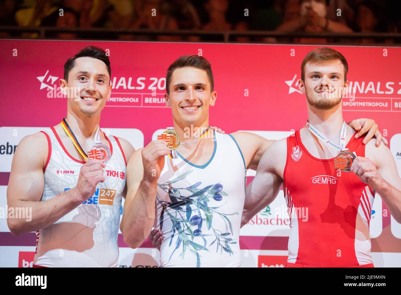 Berlin, Germany. 26th June, 2022. Gymnastics: German Championship, apparatus finals 2 men, high bar. Andreas Toba (2nd place), Carlo Hörr (1st place) and Leonard Prügel (3rd place) at the award ceremony. Credit: Christoph Soeder/dpa/Alamy Live News Stock Photo