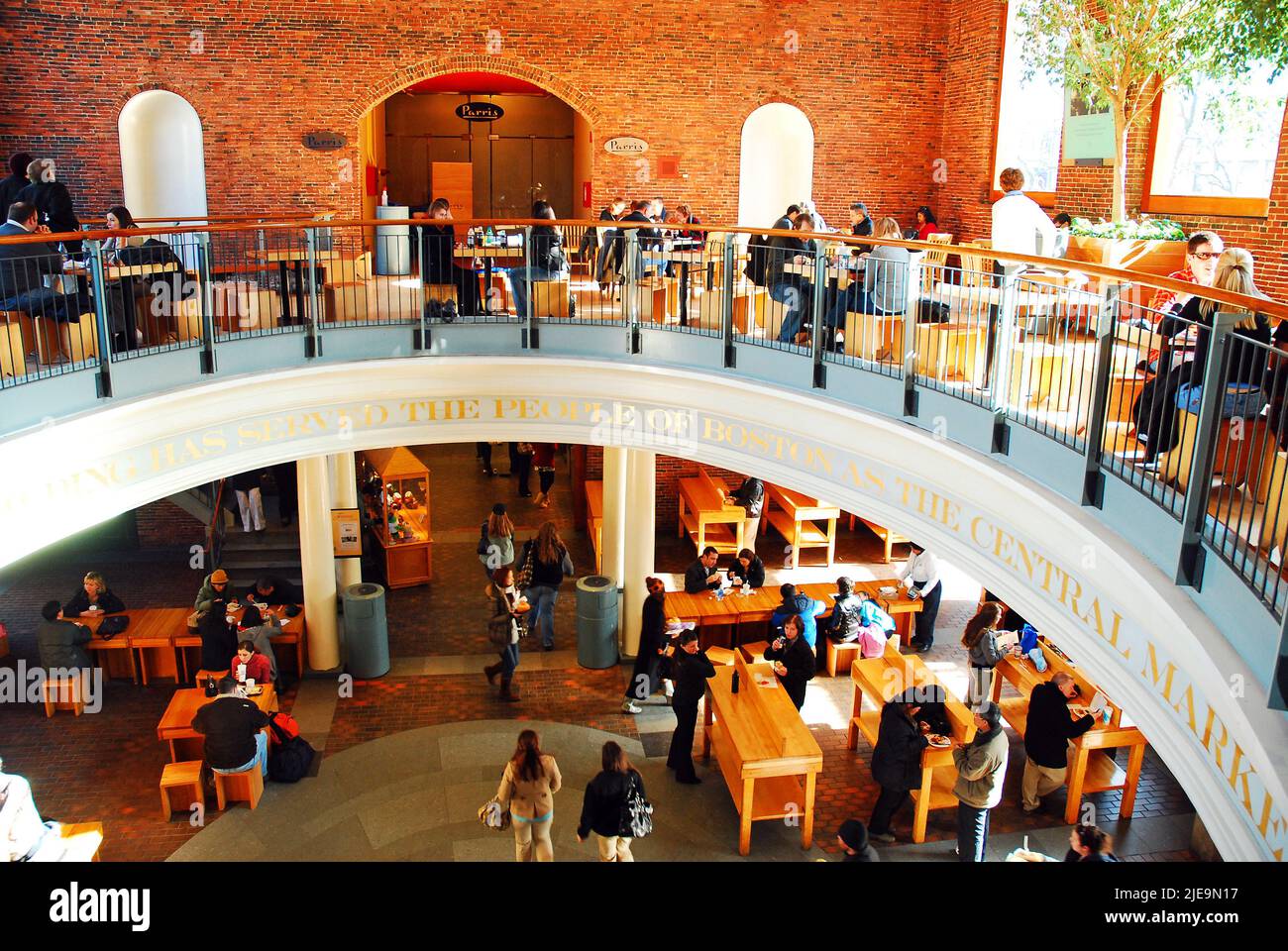 A lunchtime crowd of people gather at the tables of Boston’s Quincy Market Stock Photo