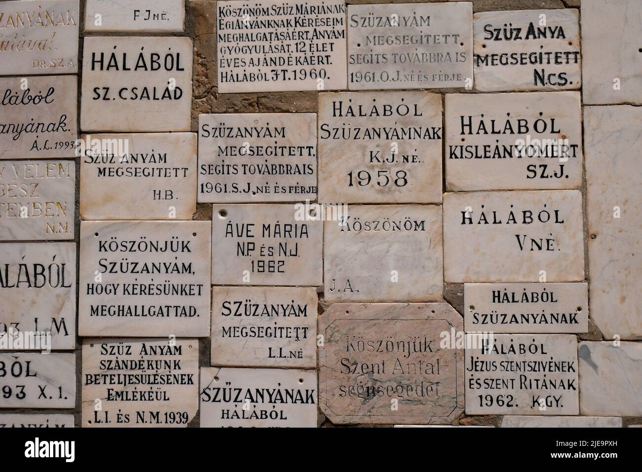 Memorial plaques on a wall next to the entrance gate, St Nicholas Catholic Church,  Szent Miklos templom, Kecskemet, Hungary Stock Photo