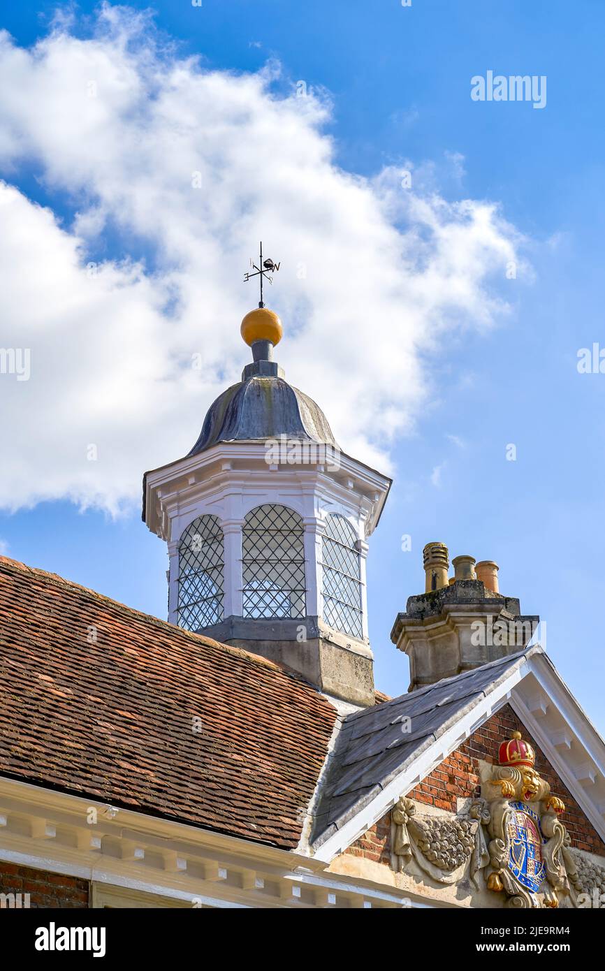 Turret with leaded windows weather vane and lightning conductor on top of a tiled roof Stock Photo