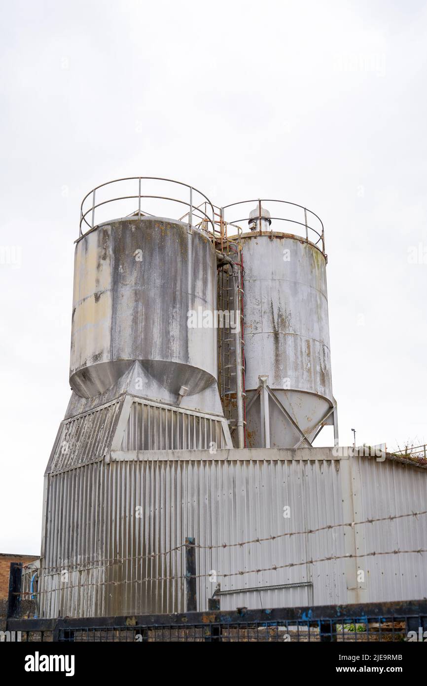 Large metal industrial storage containers against white sky with copy