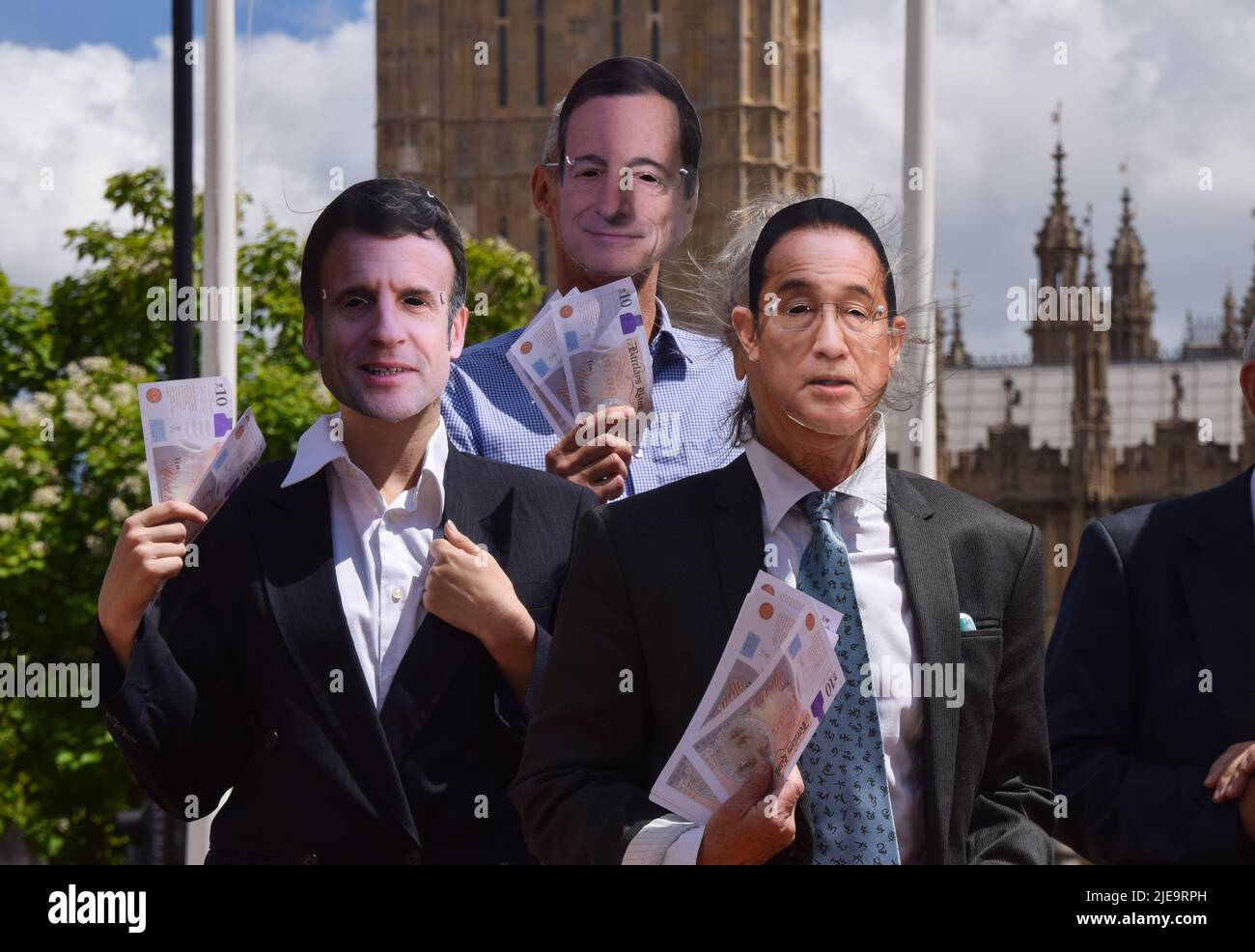 London, England, UK. 26th June, 2022. Protesters dressed as Emmanuel Macron, Mario Draghi and Fumio Kishida. Extinction Rebellion activists dressed as G7 leaders played a football match in Parliament Square against ''˜Indebted countries', whose players were weighed down by debt chained to their legs, with the match rigged in the G7's favour by a ''˜banker referee'. The action was part of the day's protest demanding that the G7 cancels the debt of the countries in the Global South, which is forcing the nations to extract fossil fuels to pay off the debts. (Credit Image: © Vuk Va Stock Photo