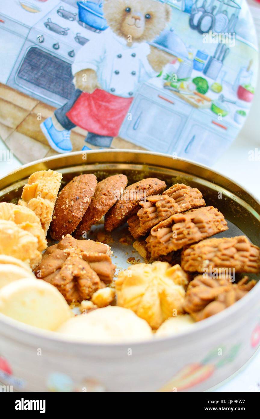 Hong Kong, August 2018. Mixed flavour cookies from Hong Kong Jenny Bakery in a round container with a lid at background. Stock Photo