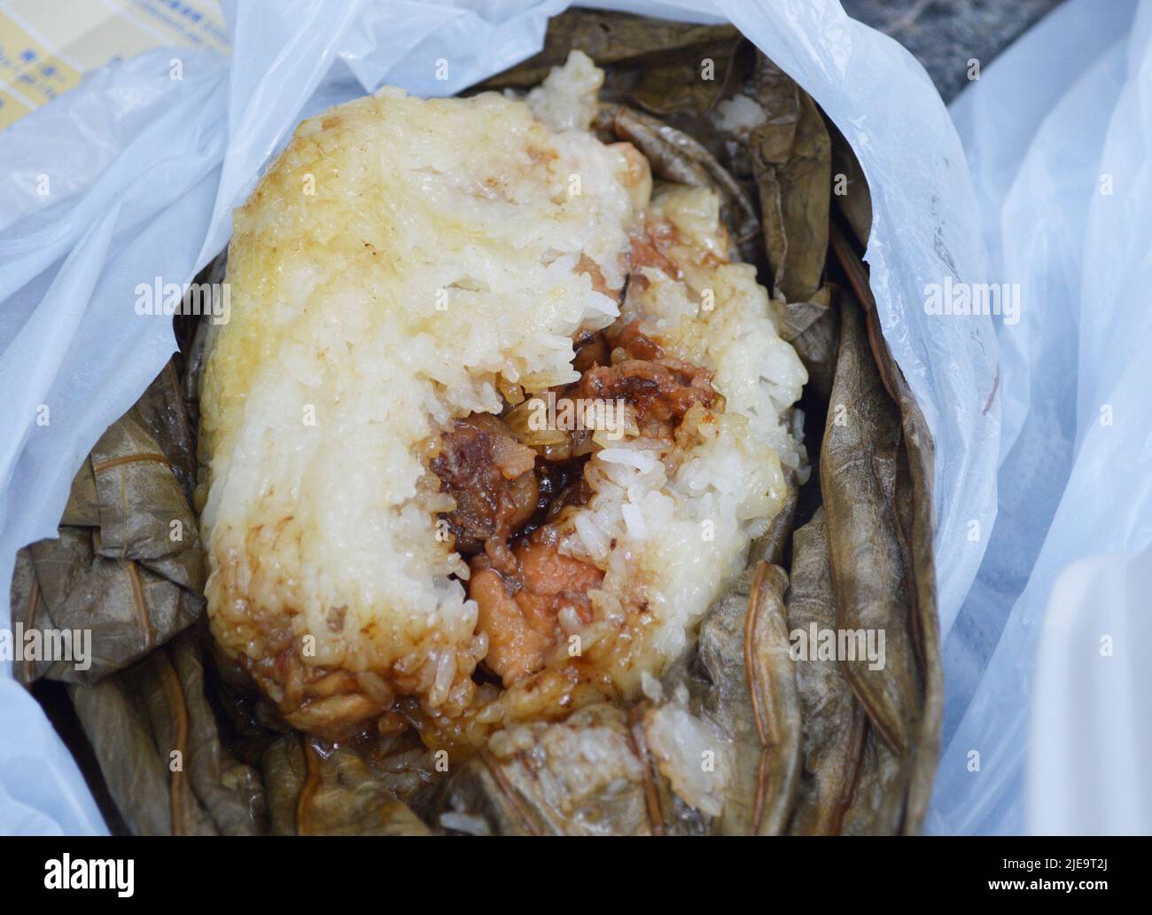 Famous Hong Kong dim sum 'Lo Mai Gai', the glutinous rice with meat and mushroom wrapped by lotus leaf. Stock Photo