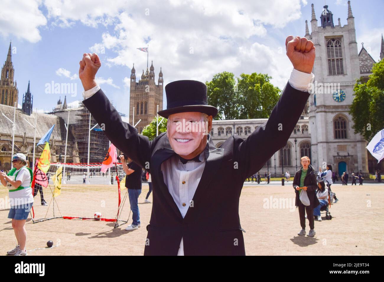 London, England, UK. 26th June, 2022. A protester dressed as Joe Biden celebrates a goal. Extinction Rebellion activists dressed as G7 leaders played a football match in Parliament Square against ''˜Indebted countries', whose players were weighed down by debt chained to their legs, with the match rigged in the G7's favour by a ''˜banker referee'. The action was part of the day's protest demanding that the G7 cancels the debt of the countries in the Global South, which is forcing the nations to extract fossil fuels to pay off the debts. (Credit Image: © Vuk Valcic/ZUMA Press Wir Stock Photo