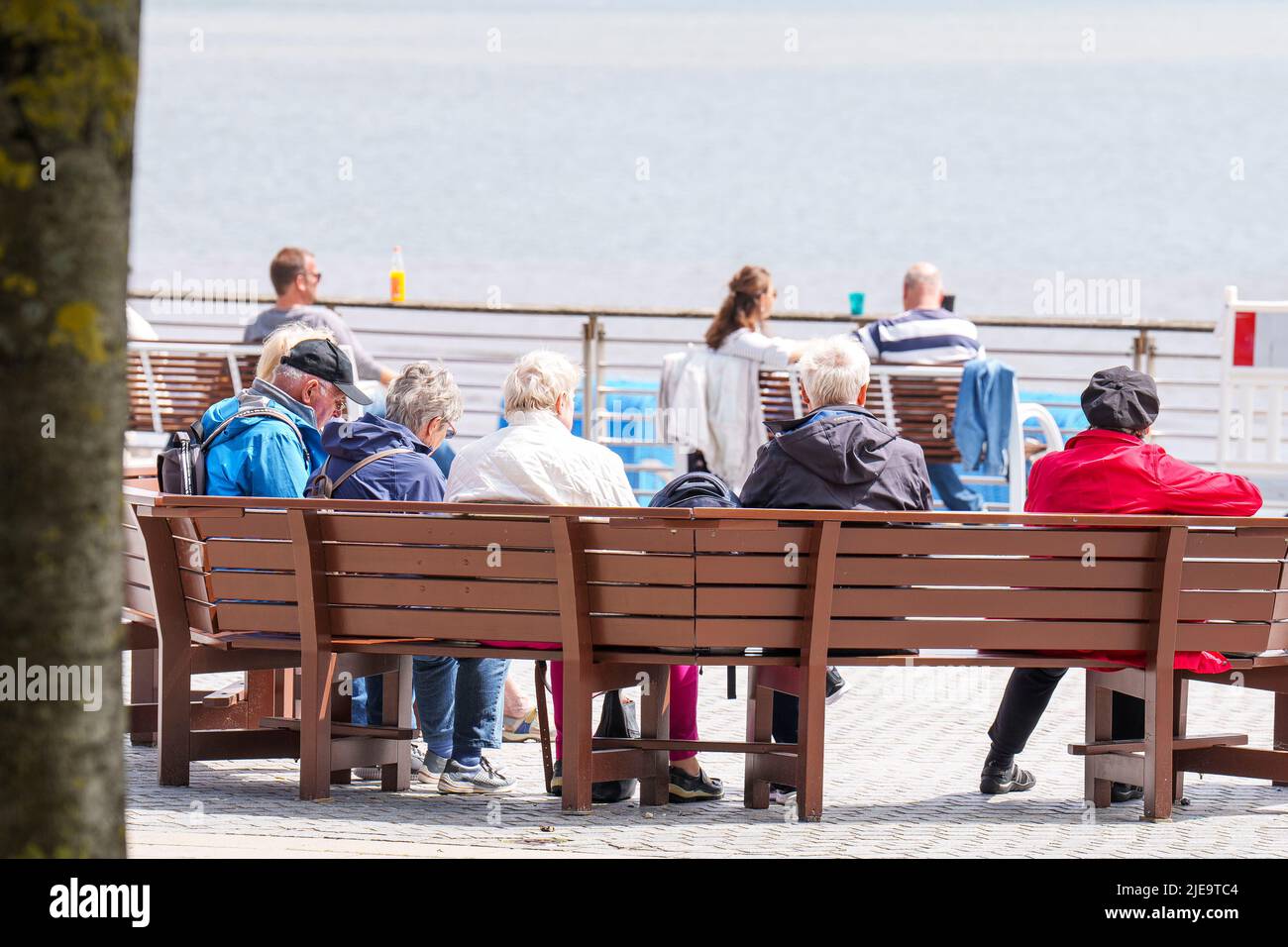 Senior people on a bench at the beach  on Juni 21, 2022  in Wyk, Foehr Island, Germany.  © Peter Schatz / Alamy Stock Photos Stock Photo