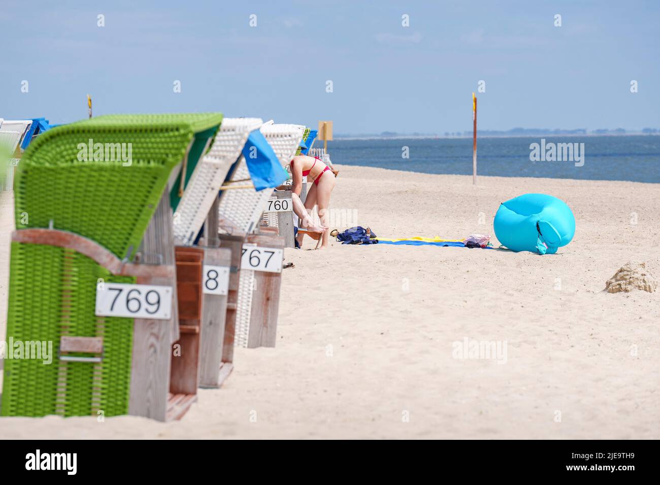 Tourists in colorful beach chairs on the beach sunbathing  on Juni 21, 2022  in Wyk, Foehr Island, Germany.  © Peter Schatz / Alamy Stock Photos Stock Photo
