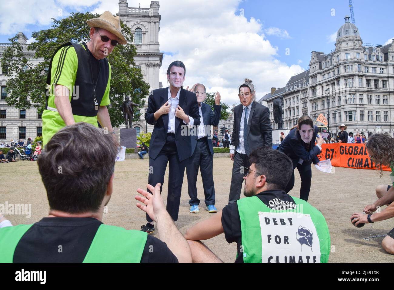 London, UK. 26th June 2022. Extinction Rebellion activists dressed as G7 leaders played a football match in Parliament Square against ‘Indebted countries', whose players were weighed down by debt chained to their legs, with the match rigged in the G7’s favour by a ‘banker referee’. The action was part of the day’s protest demanding that the G7 cancels the debt of the countries in the Global South, which is forcing the nations to extract fossil fuels to pay off the debts. Credit: Vuk Valcic/Alamy Live News Stock Photo