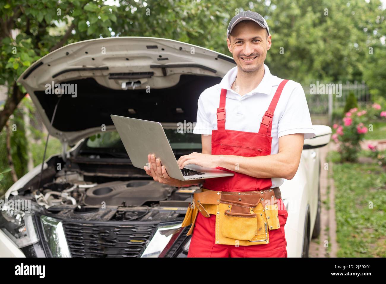 Car mechanic open hood to repair and check car problem system by laptop