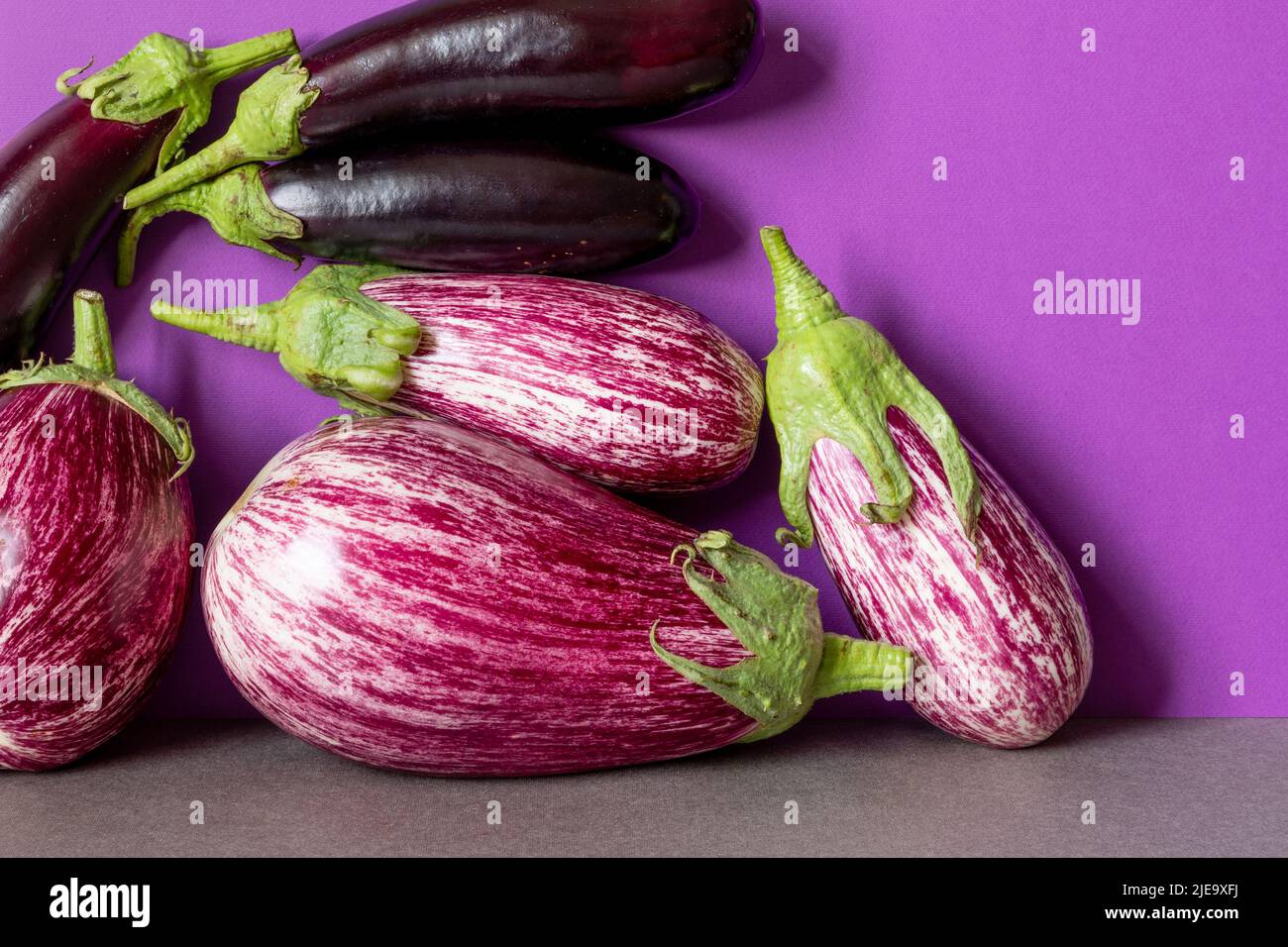 Three ripe eggplants with beautiful purple and pink striped patterns. Natural organic farm vegetable food concept. Stock Photo