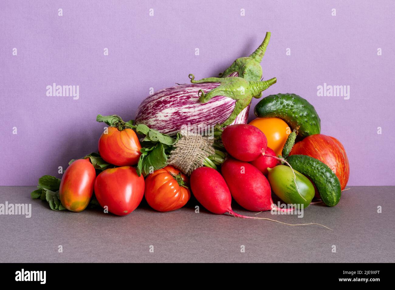 Healthy vegetarian food organic vegetables still life concept. Farm aubergine eggplants, tomatoes of various grade, bell peppers, carrot and cucumber Stock Photo