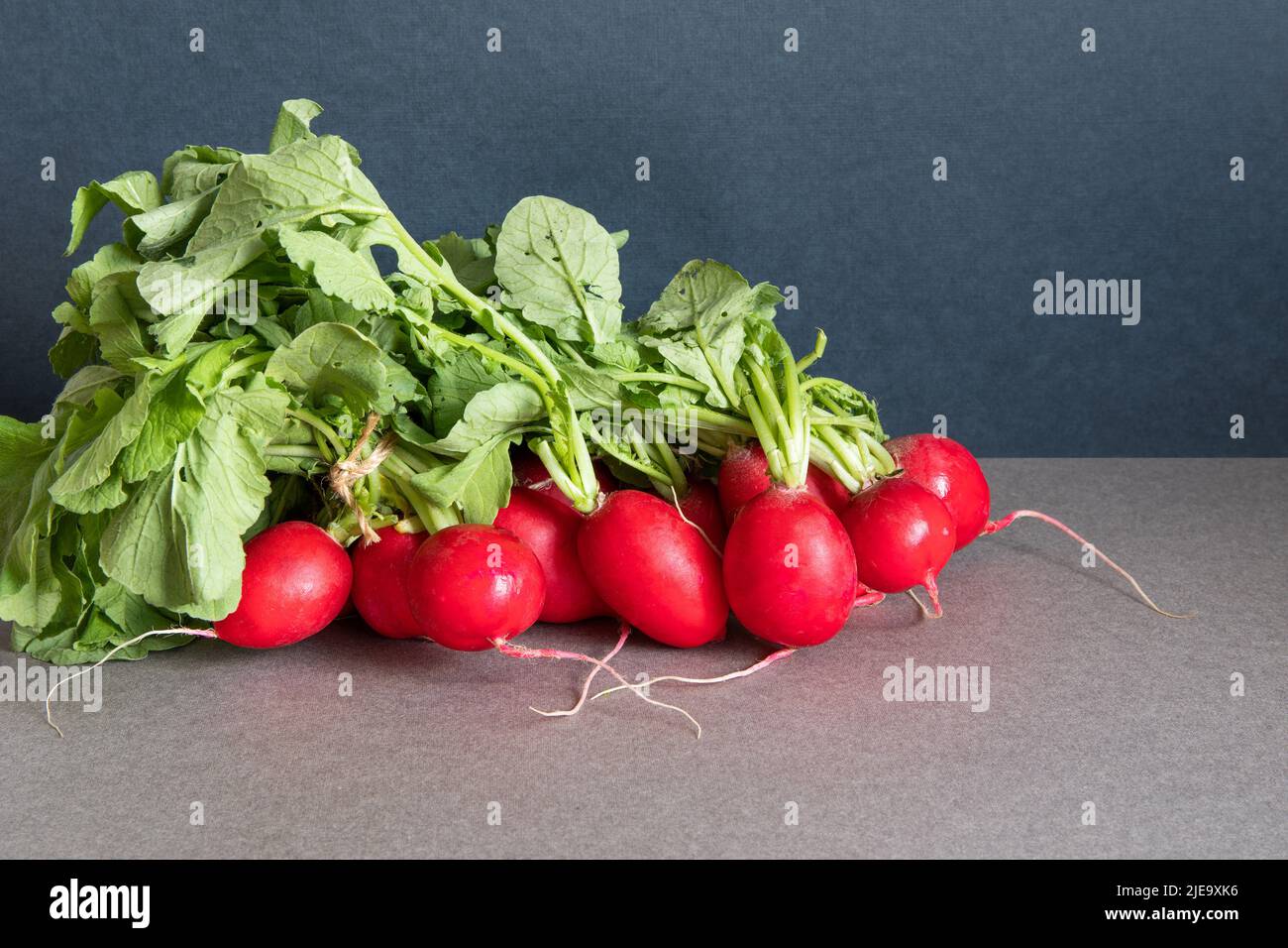 A bunch of ripe radishes with fresh green leaves. Farm harvest of summer vegetables Stock Photo