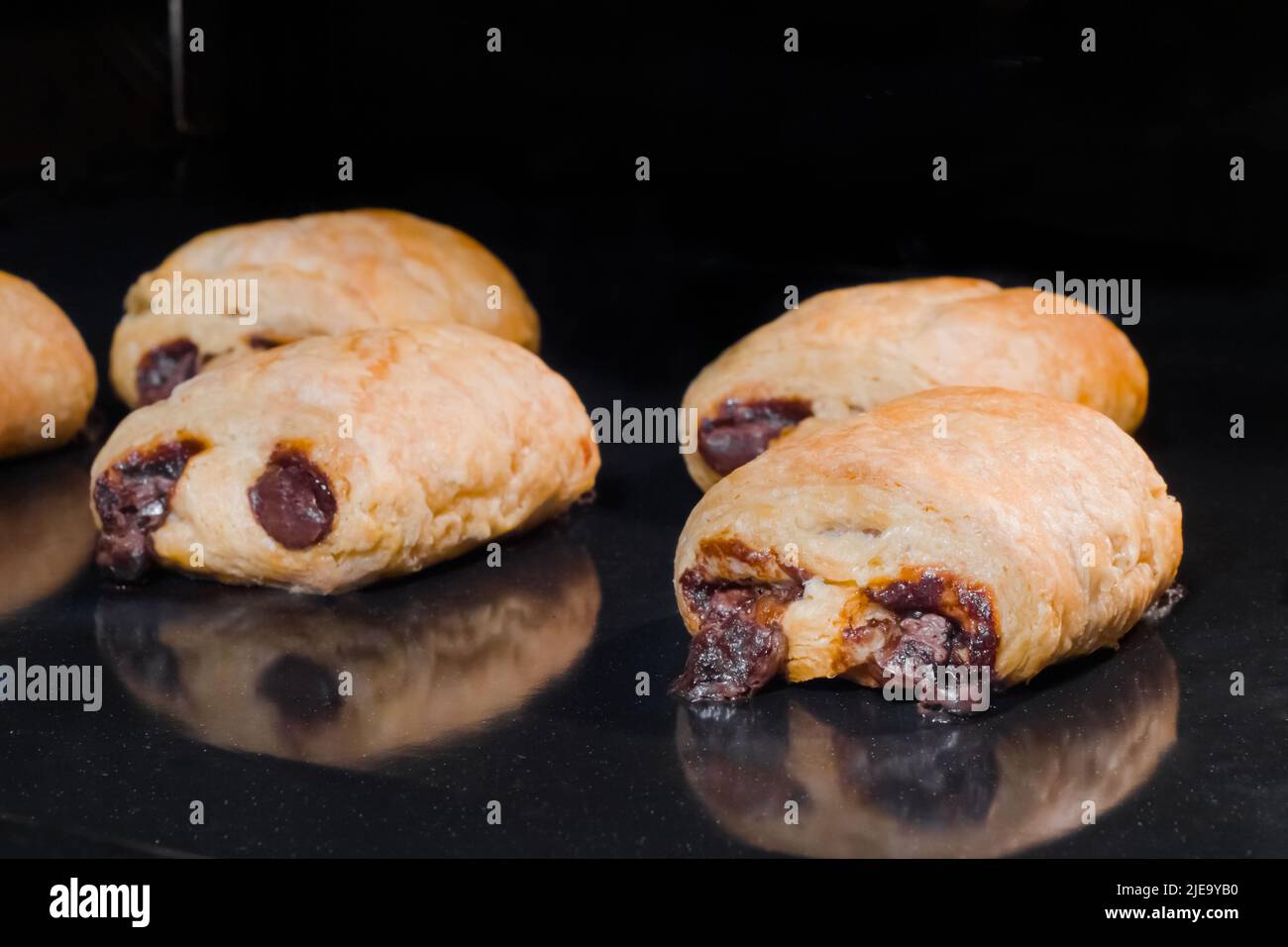 Many baked mini homemade buns with chocolate filling in electric oven