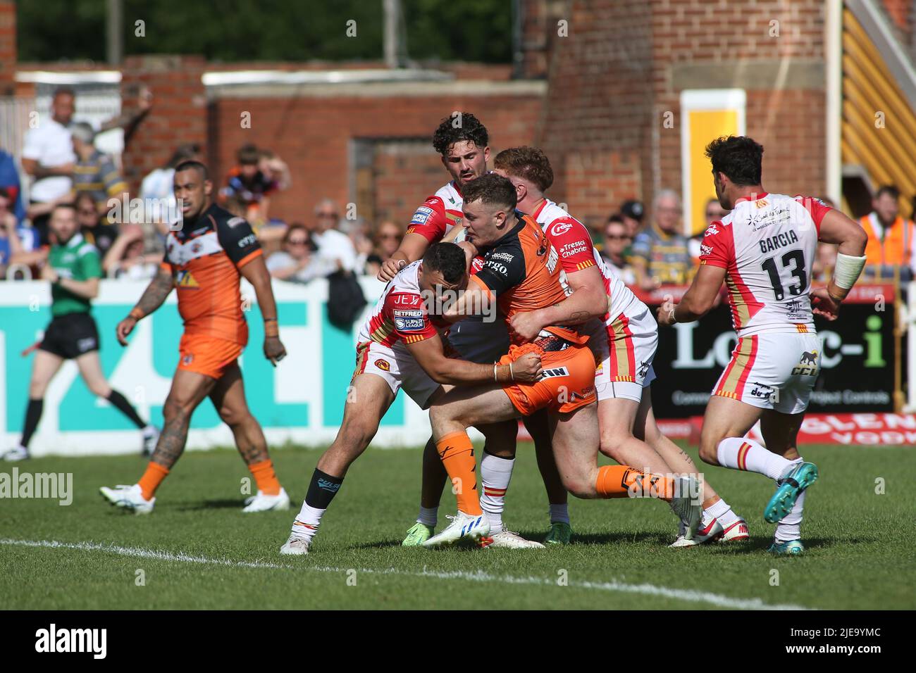 Castleford, UK. 26th June, 2022. The Mend-A-Hose Jungle, Castleford, West Yorkshire, 26th June 2022. Betfred Super League Castleford Tigers vs Catalan Dragons Jake Trueman of Castleford Tigers is tackled by 3 Catalan Dragons defenders. Credit: Touchlinepics/Alamy Live News Stock Photo