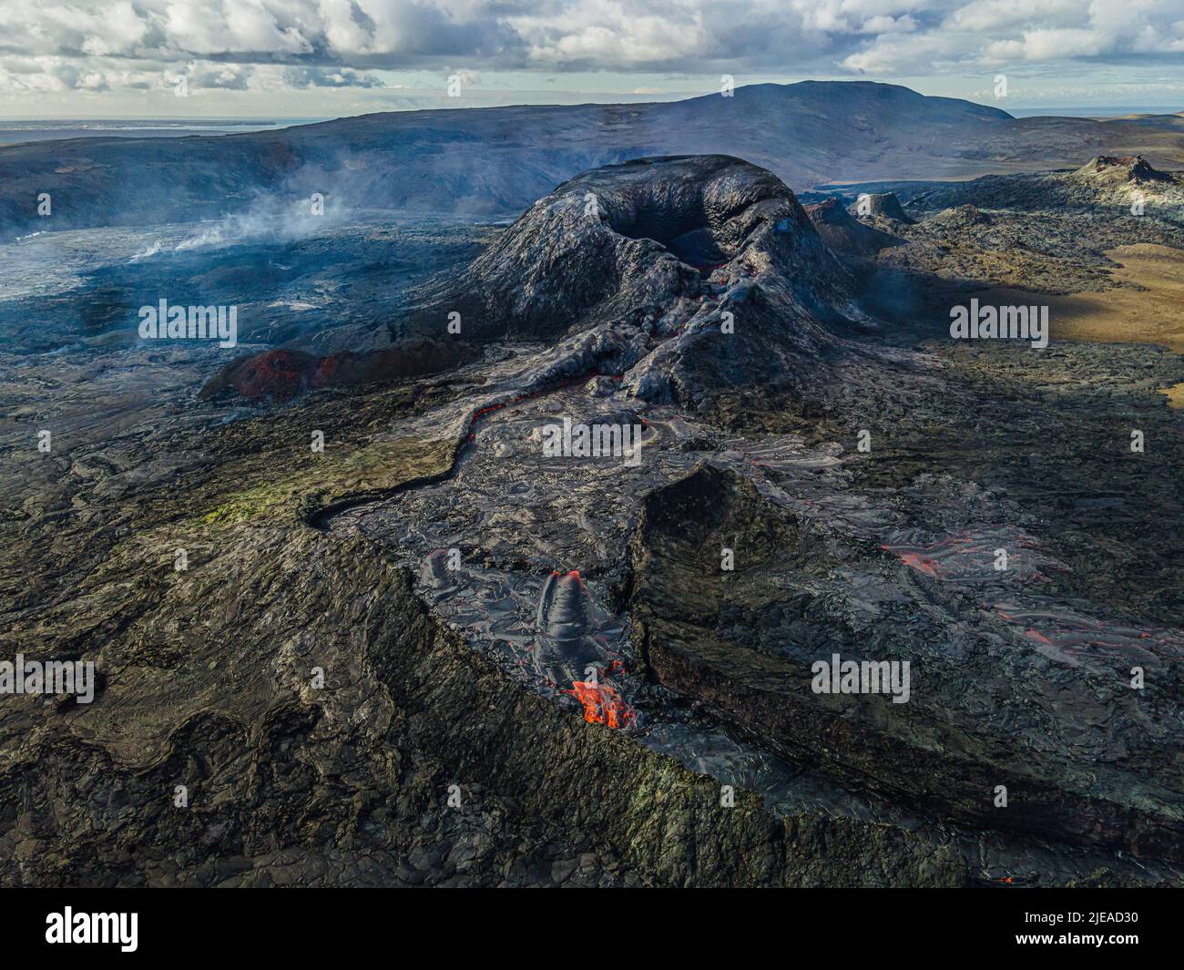 Top view of active crater on Iceland's Reykjanes Peninsula. Landscape of cooled lava flow around the crater with individual steam columns. green, blac Stock Photo