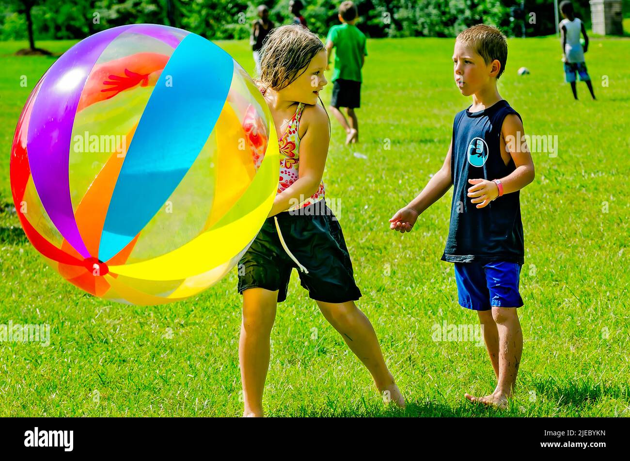 A girl plays keep-away with a giant beach ball as a boy tries to intercept it, July 27, 2012, in Columbus, Mississippi. Stock Photo