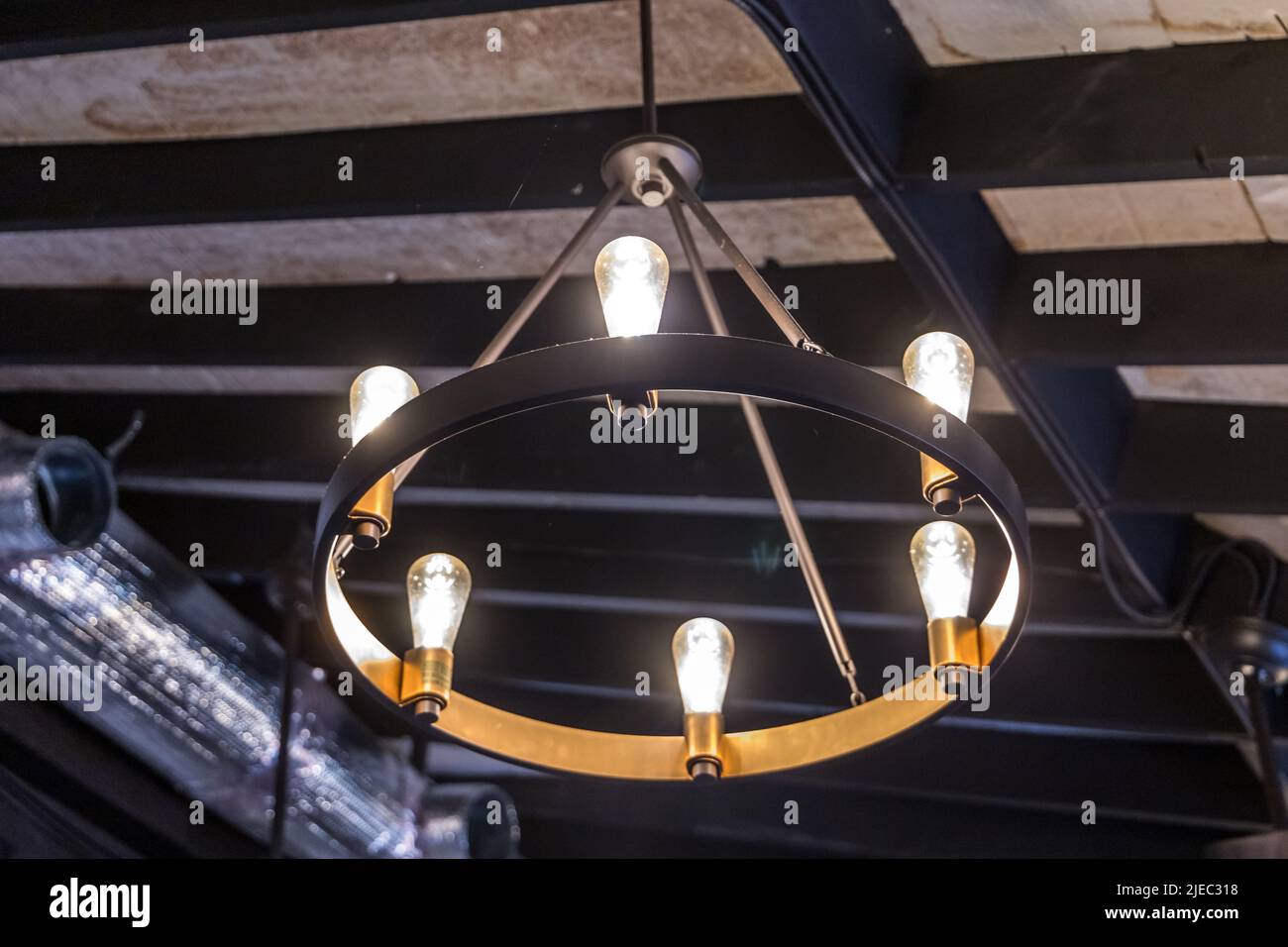 A rustic hanging mid-evil type light fixture or lantern hung from a high ceiling Stock Photo