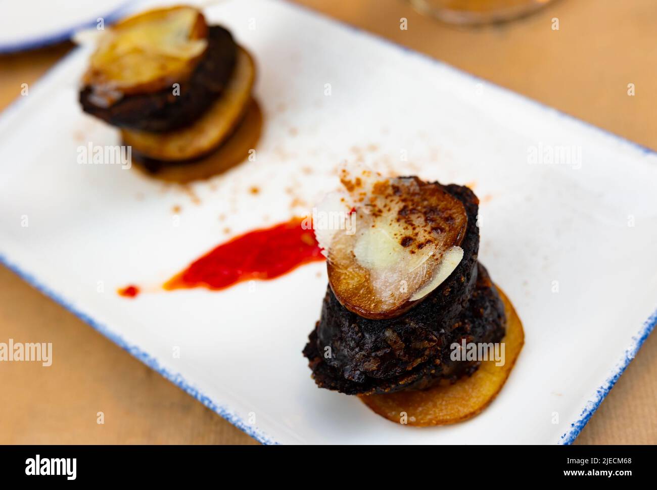 Spanish timbale of morcilla with caramelized pears and cheese Stock