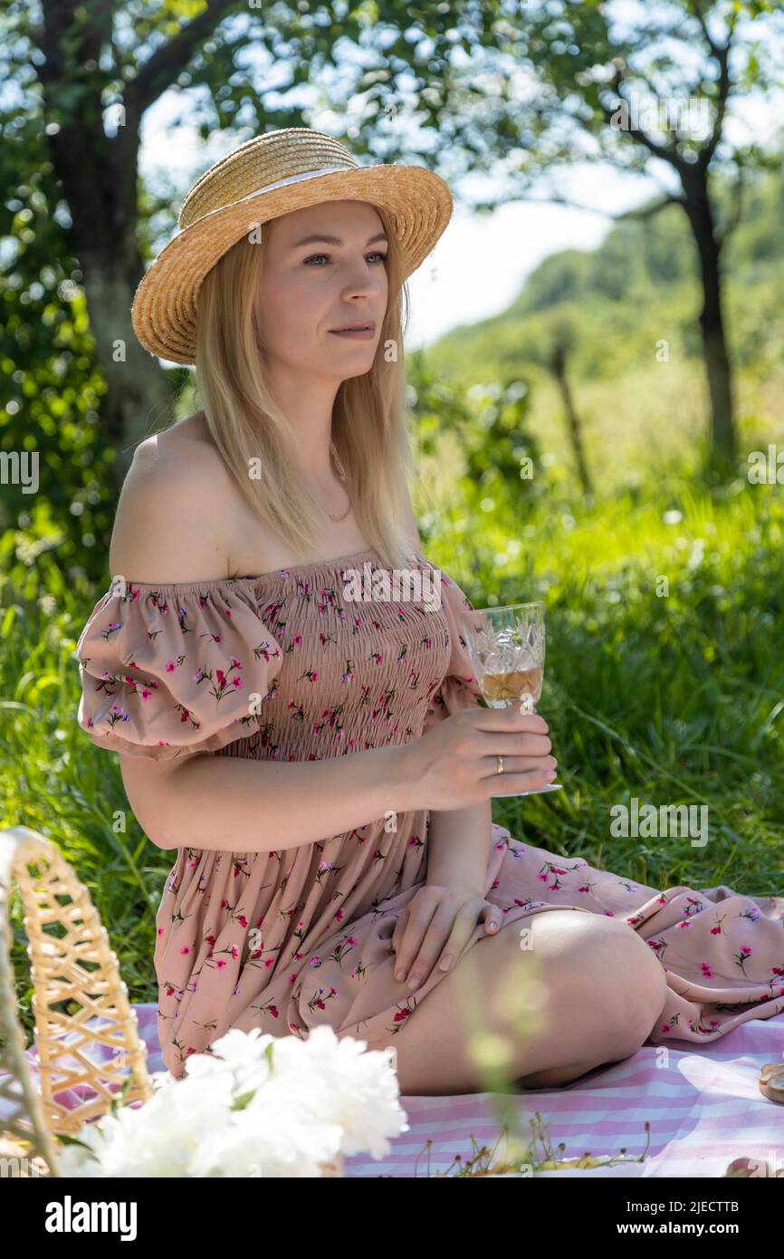 Beautiful woman in a straw hat with a glass of wine in hand. On vacation. Stock Photo