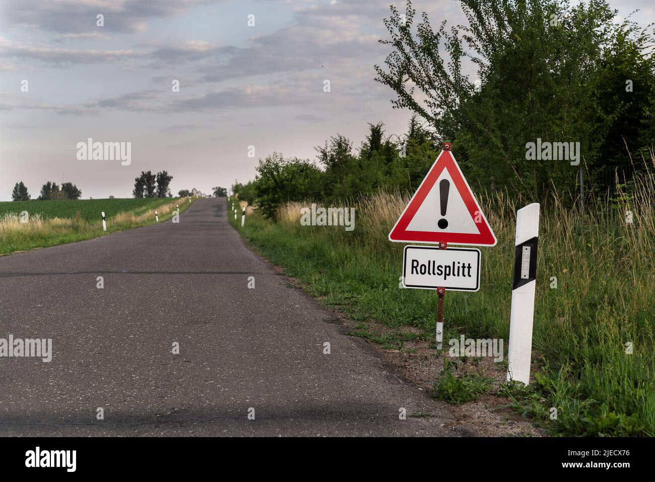 A sign with the inscription in German , Attention rolling grit , at the roadside Stock Photo