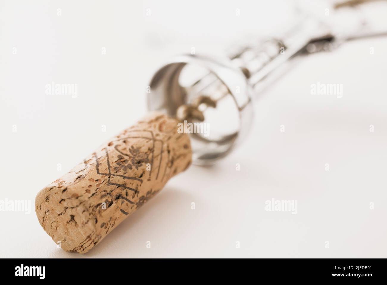 Close-up of wine bottle cork and corkscrew on white background. Stock Photo