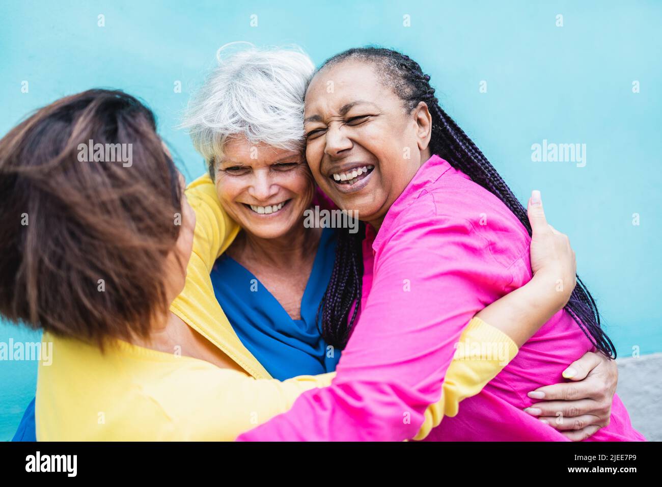 Happy multiracial senior women having fun hugging each other outdoor - Older community lifestyle Stock Photo