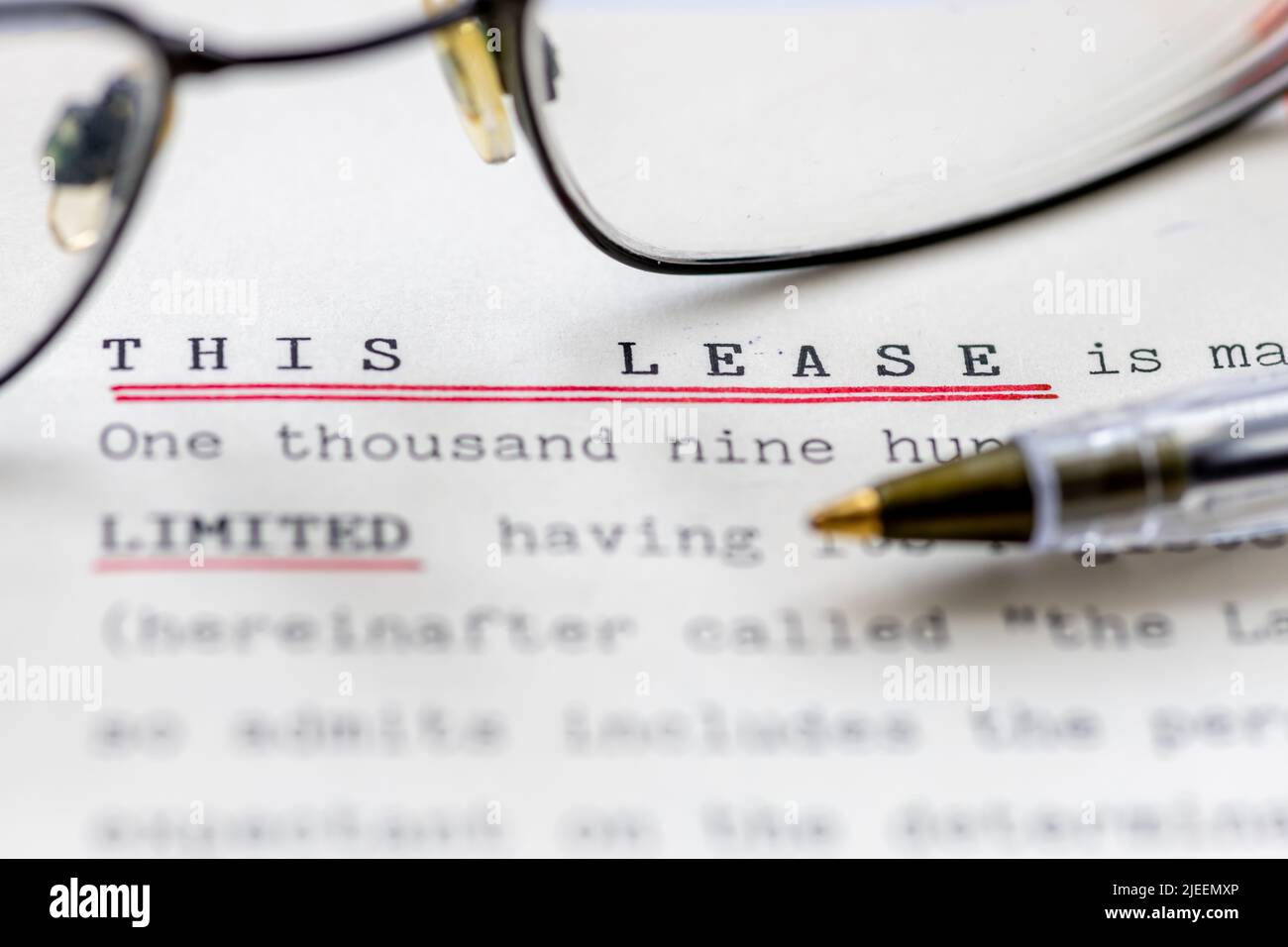 Close up of a lease for a property shown with eye glasses. A legal document for long term rental or ownership of a business premise or home. Stock Photo
