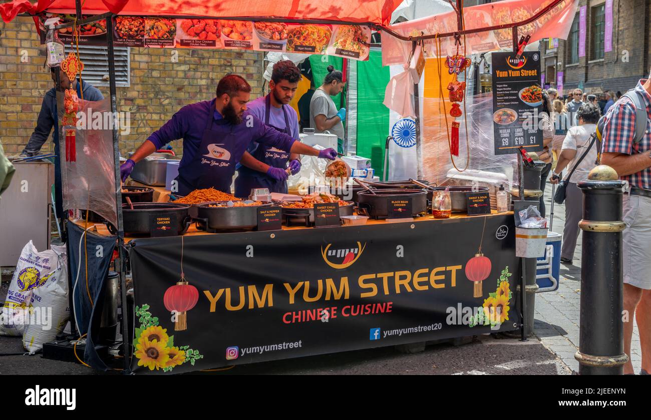 London. UK-06.26.2022. A large crowd of tourists and visitors in Brick Lane Market visiting the street food stalls. Stock Photo