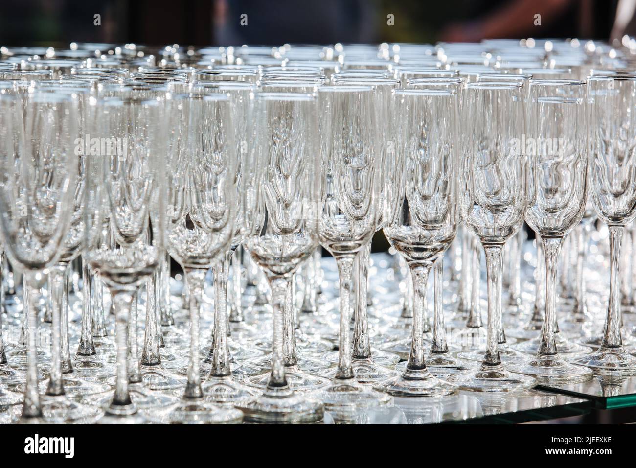 Empty glass transparent wine glasses on a table, catering background concept. Stock Photo