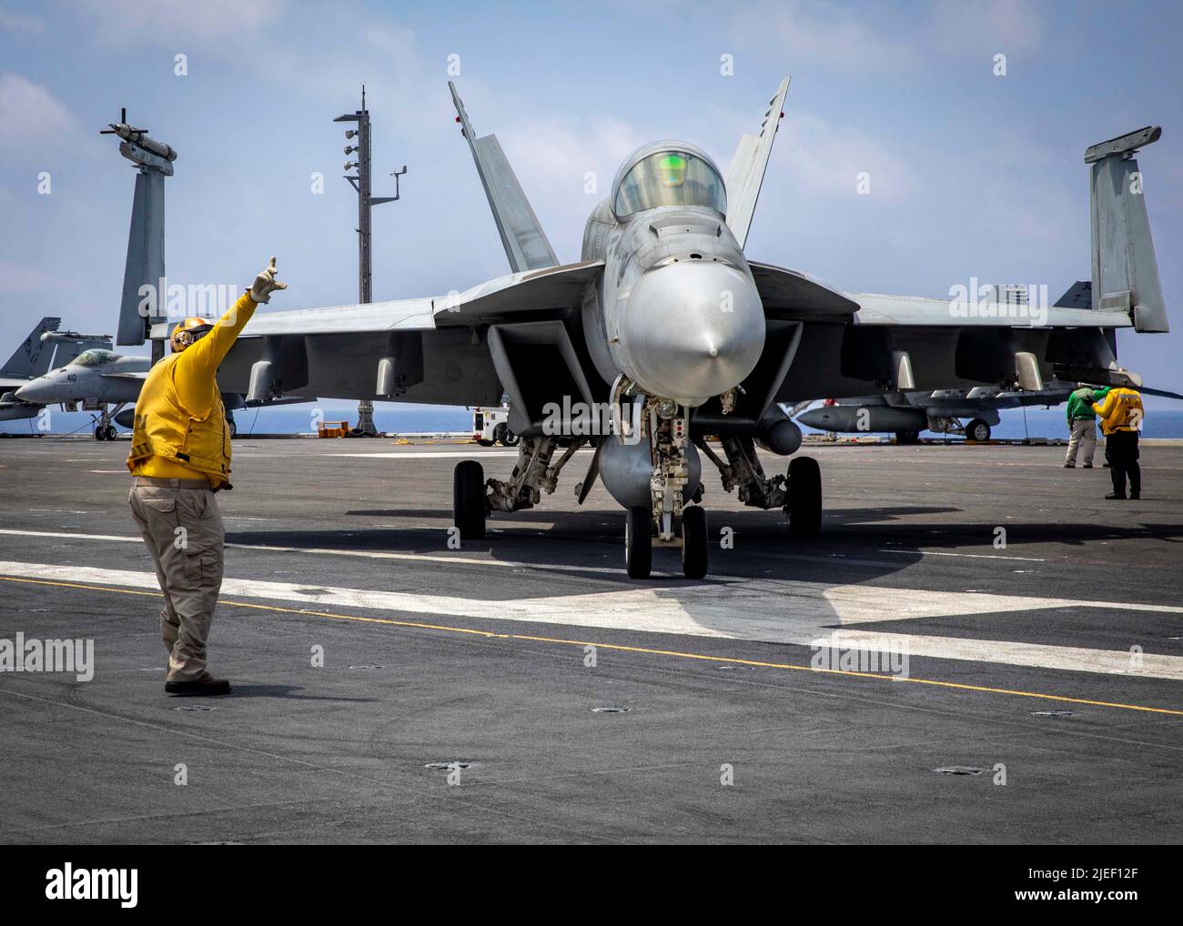 220624-N-OL632-1334 ATLANTIC OCEAN (June 24, 2022) Master Chief Aviation Boatswain’s Mate Shannon Hawkins, signals F/A-18E Super Hornet aircraft attached to Strike Fighter Squadron (VFA) 103 on the flight deck of the Nimitz-class aircraft carrier USS George H.W. Bush (CVN 77), June 24, 2022. The George H.W. Bush Carrier Strike Group (CSG) is underway completing a certification exercise to increase U.S. and allied interoperability and warfighting capability before a future deployment. The George H.W. Bush CSG is an integrated combat weapons system that delivers superior combat capability to det Stock Photo