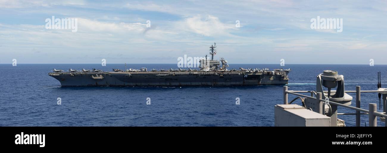 The U.S. Navy aircraft carrier USS Abraham Lincoln (CVN 72) is underway in formation during Valiant Shield 2022 (VS22), June 12, 2022. Exercises such as Valiant Shield allows the Indo-Pacific Command Joint Task Force the opportunity to integrate forces from all branches of service to conduct long-range, precise, lethal, and overwhelming multi-axis, multi-domain effects that demonstrate the strength and versatility of the Joint Task Force and our commitment to a free and open Indo-Pacific. (U.S. Marine Corps photo by Sgt. Jackson Ricker) Stock Photo