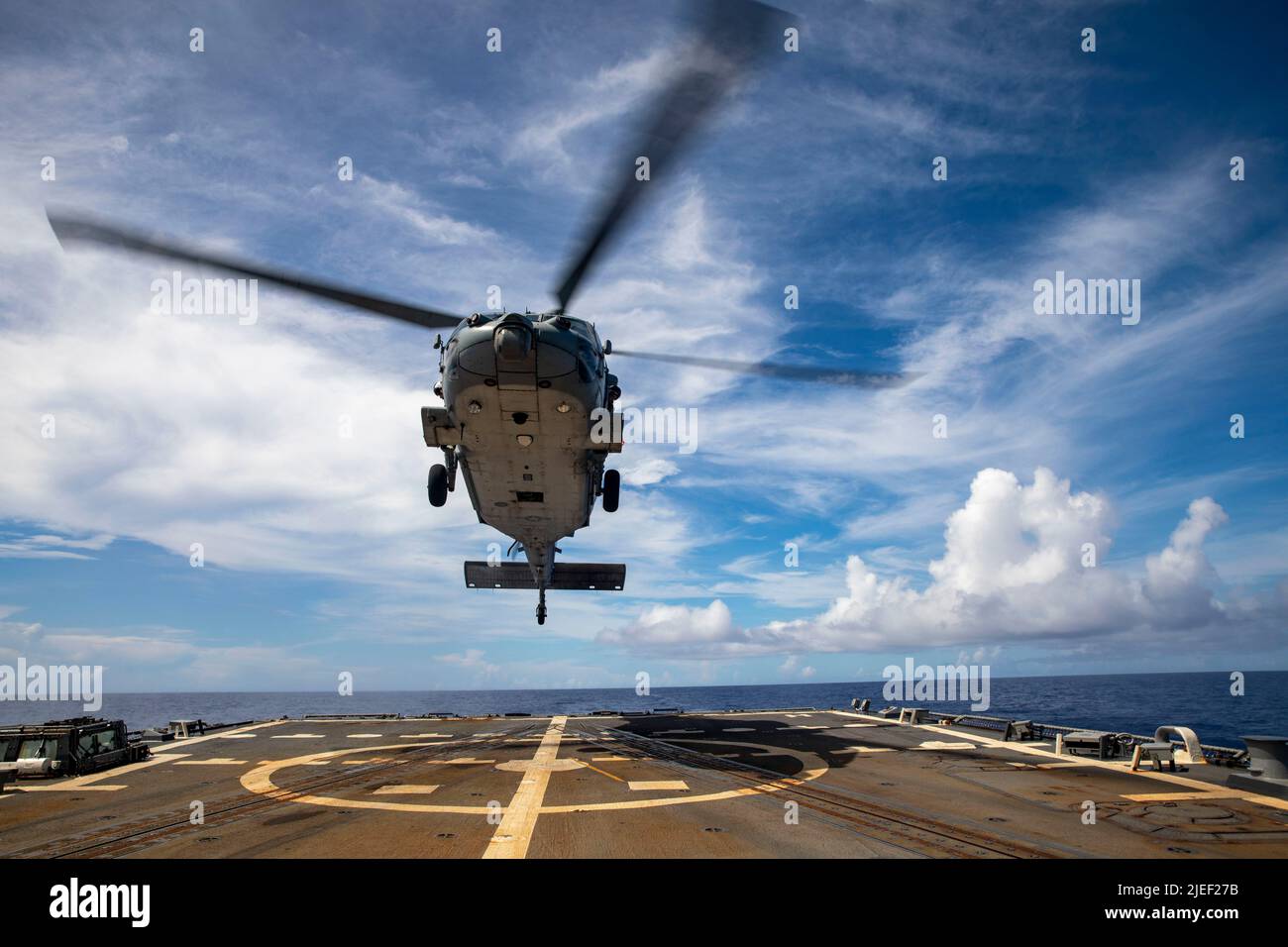 PHILIPPINE SEA (June 2, 2022) An MH-60S Sea Hawk helicopter, assigned to the “Chargers” of Helicopter Sea Combat Squadron (HSC) 14, prepares to land on the flight deck of the Arleigh Burke-class guided-missile destroyer USS Dewey (DDG 105) during a vertical replenishment with Ticonderoga-class guided-missile cruiser USS Mobile Bay (CG 53). Abraham Lincoln Strike Group is on a scheduled deployment in the U.S. 7th Fleet area of operations to enhance interoperability through alliances and partnerships while serving as a ready-response force in support of a free and open Indo-Pacific region. (U.S. Stock Photo