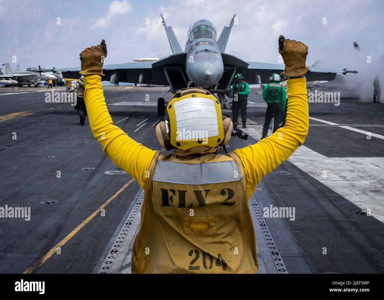 220624-N-OL632-1233 ATLANTIC OCEAN (June 24, 2022) Aviation Boatswain’s Mate (Handling) 2nd Class Kayla Fowler, signals an F/A-18E Super Hornet aircraft attached to Strike Fighter Squadron (VFA) 143, on the flight deck of the Nimitz-class aircraft carrier USS George H.W. Bush (CVN 77), June 24, 2022. The George H.W. Bush Carrier Strike Group (CSG) is underway completing a certification exercise to increase U.S. and allied interoperability and warfighting capability before a future deployment. The George H.W. Bush CSG is an integrated combat weapons system that delivers superior combat capabili Stock Photo