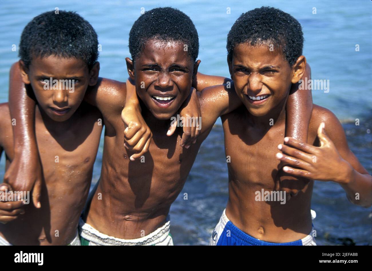 Three young boys by the sea in al-Ashkarah, Oman Stock Photo