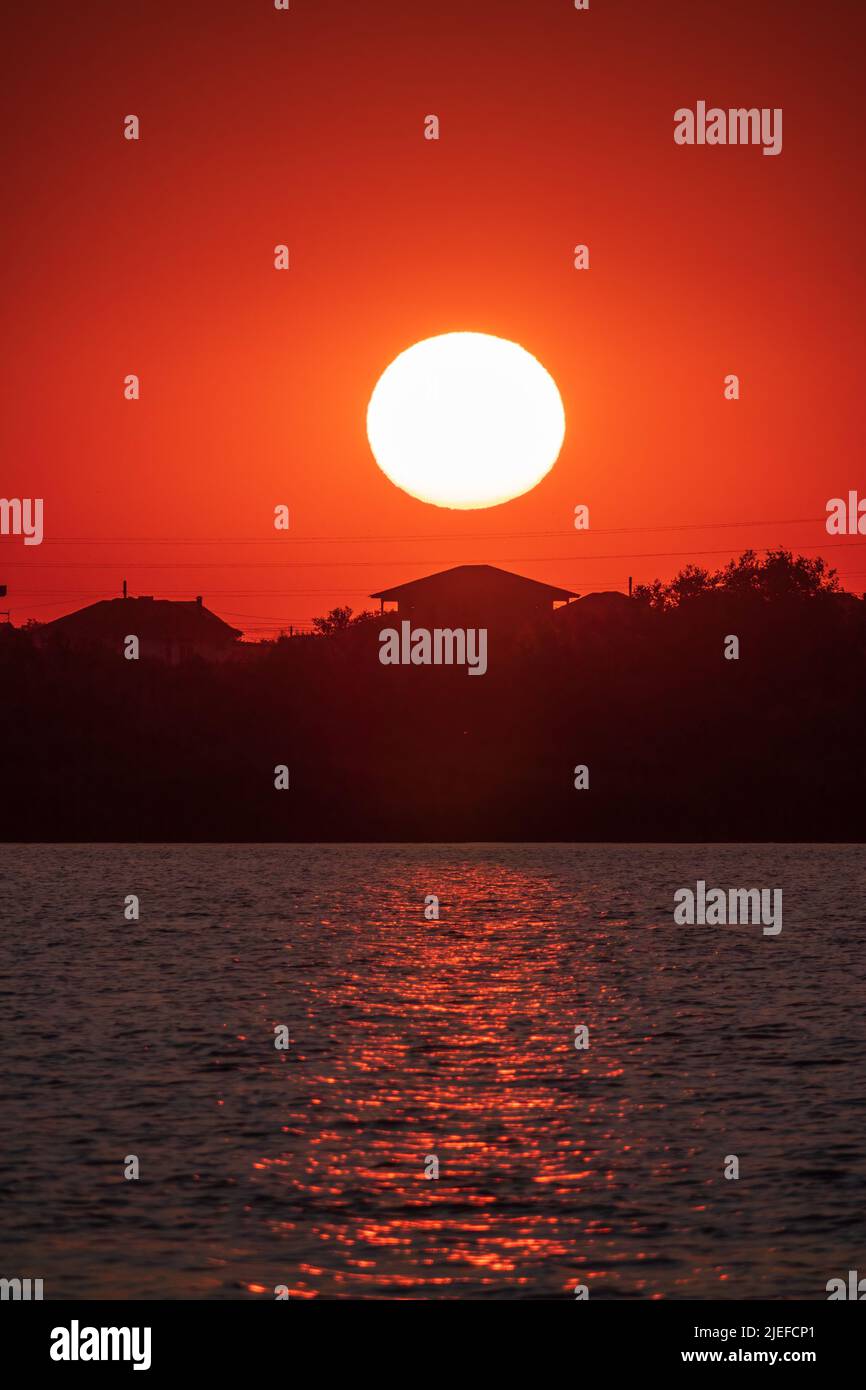 The sun goes down over a lake. Dramatic Sunset Sky Stock Photo Alamy