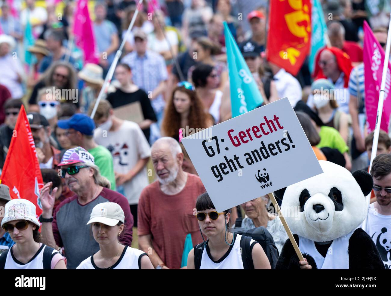 Munich, Germany. 25th June, 2022. A participant costumed as a panda holds a sign reading 'G7: Gerecht geht anders!' at a demonstration by G7 critics for better climate and species protection and against hunger and poverty. Fifteen associations critical of globalization have called for the demonstration in Munich. Germany is hosting the G7 summit (June 26-28) of economically strong democracies. Credit: Sven Hoppe/dpa/Alamy Live News Stock Photo