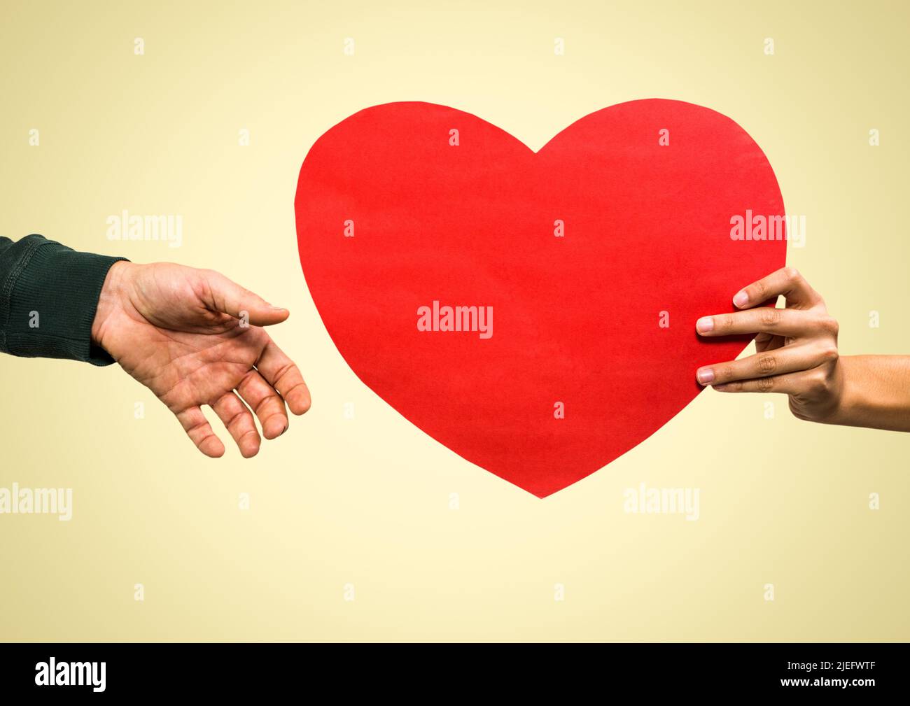 Close up of hand passing a heart shaped placard against copy space