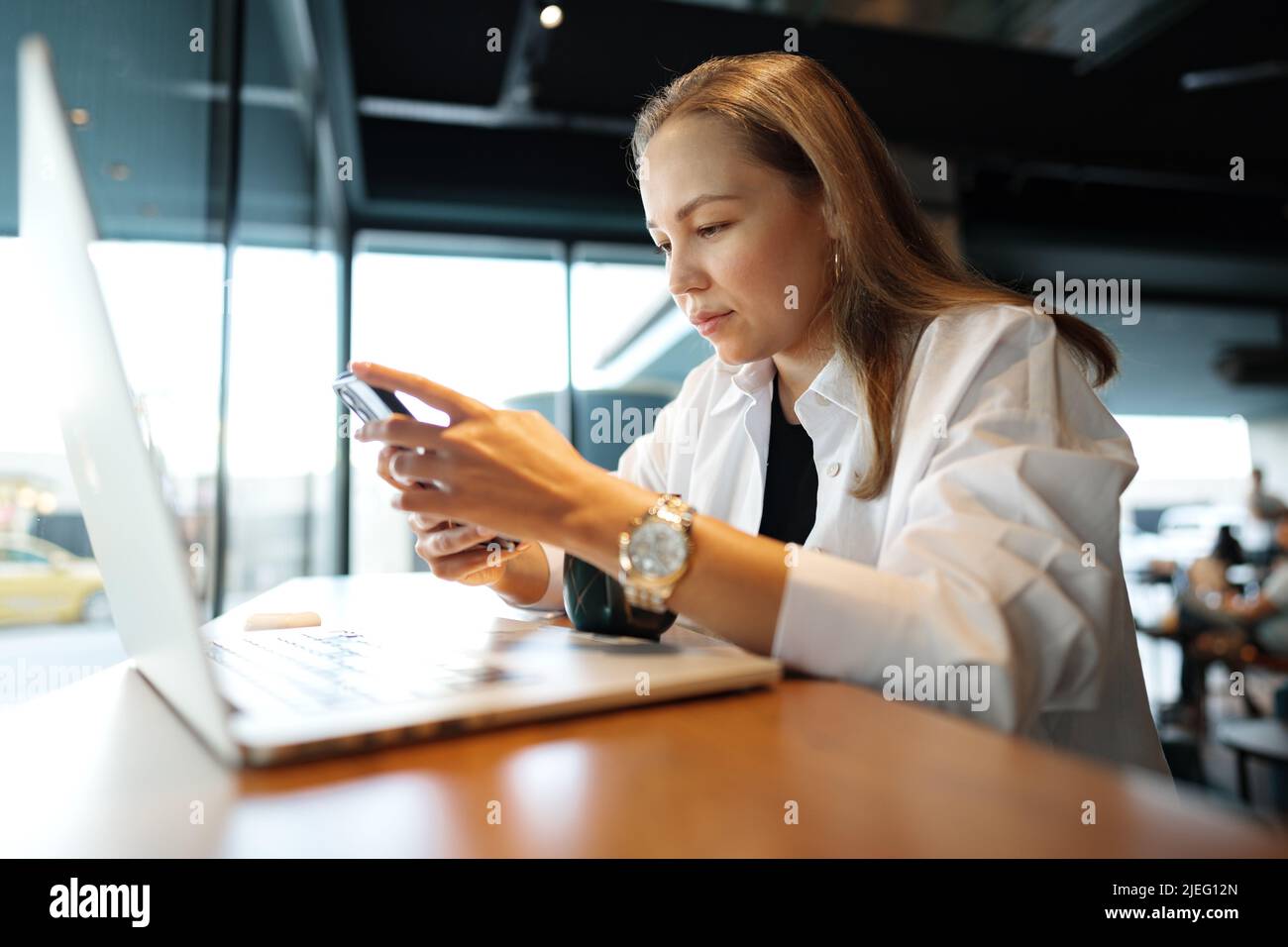 Woman typing text message on smart phone while sitting in a cafe Stock ...