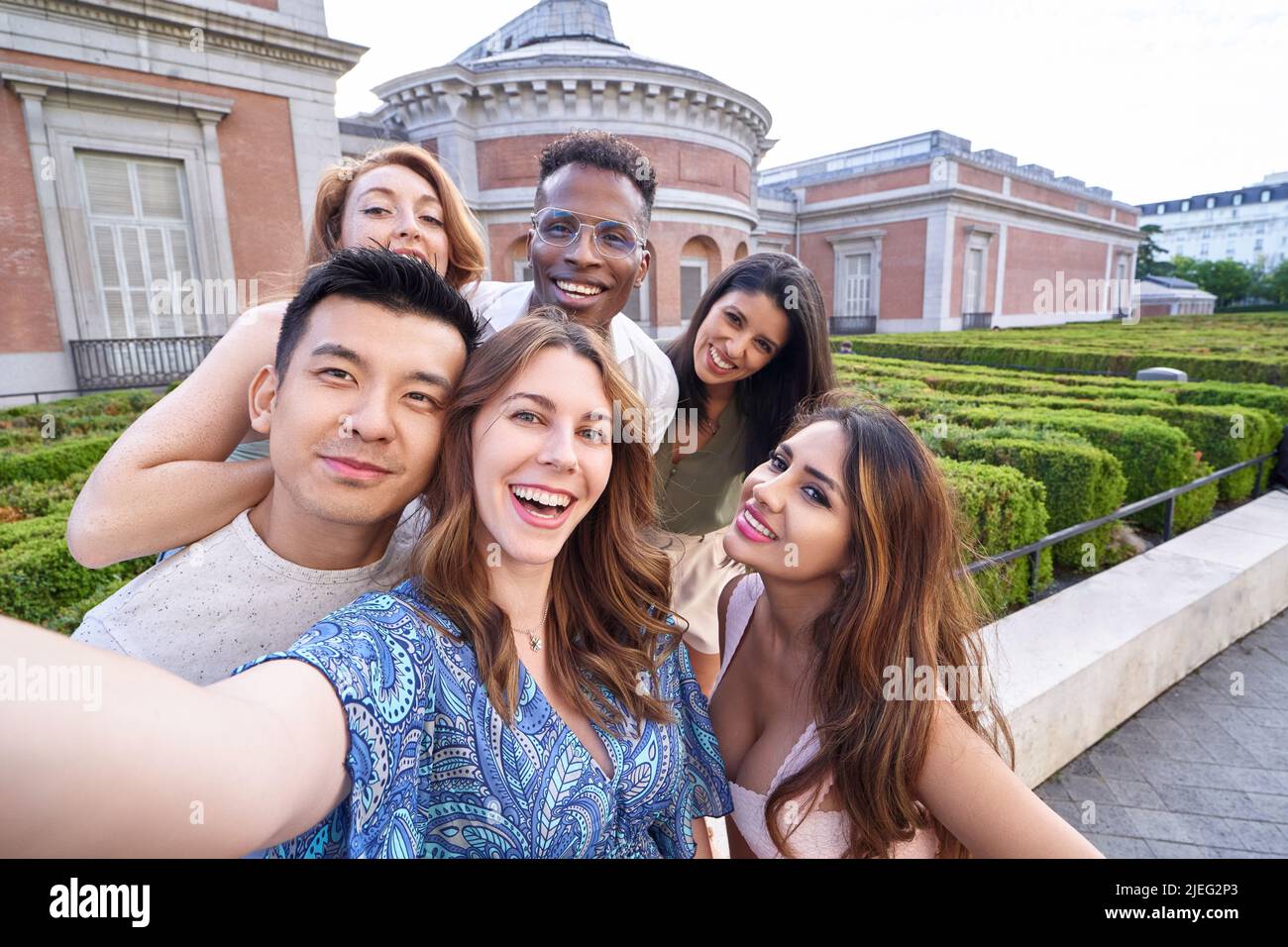 Group of multi-ethnic friends looking at camera and smiling while taking a selfie together outdoors. Friendship concept. Stock Photo