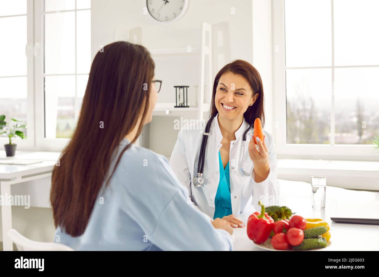 Woman doctor nutritionist talking patient about benefits of proper nutrition or vegetarianism Stock Photo