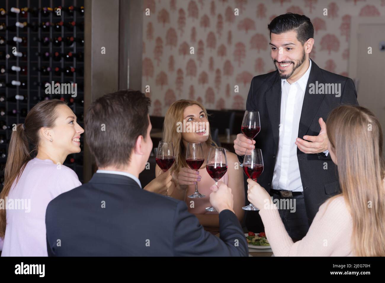 Glad man pronouncing toast in cozy restaurant Stock Photo