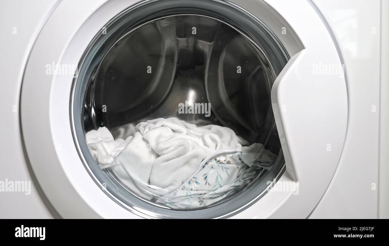 White laundry spins in washing machine drum with water Stock Photo Alamy